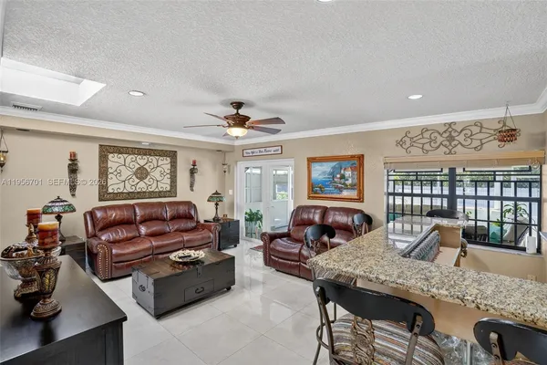 a living room with furniture kitchen view and a large window