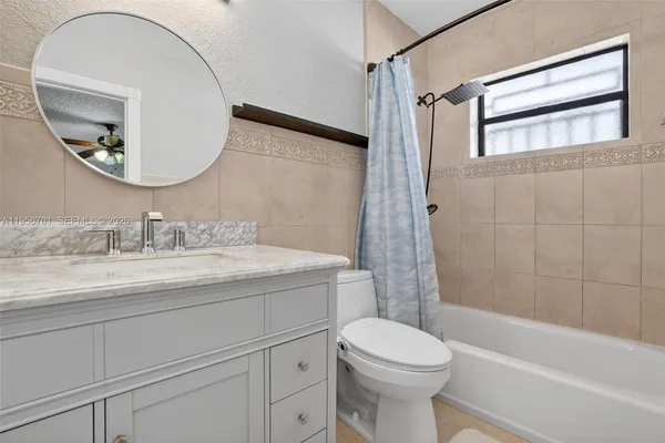 a bathroom with a granite countertop toilet a sink and a mirror