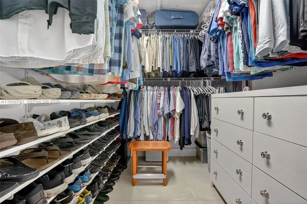 a view of walk in closet with clothes and shoes