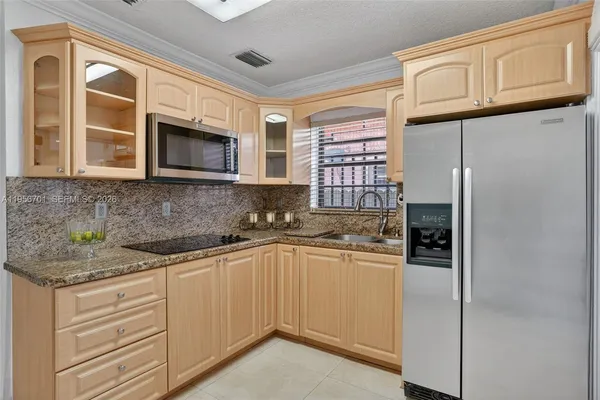 a kitchen with stainless steel appliances granite countertop a refrigerator and cabinets