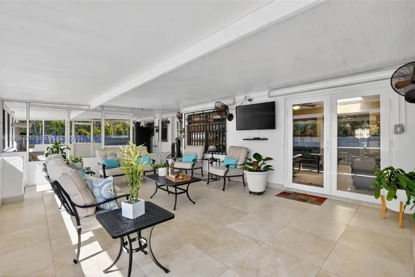 a living room with furniture potted plant and flat screen tv
