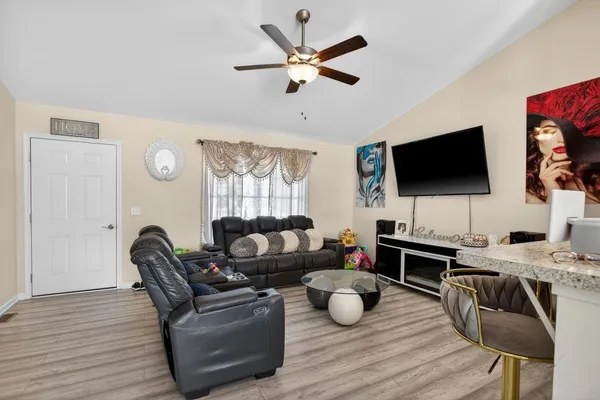 a living room with furniture a flat screen tv and a window