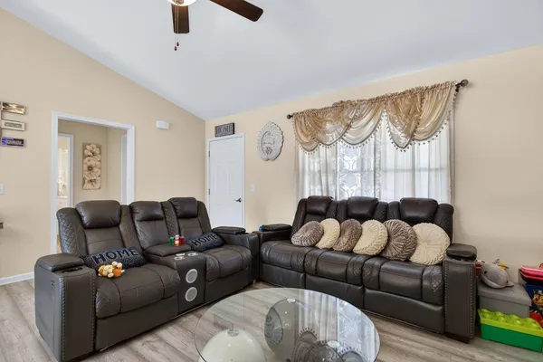 a living room with furniture a large window and a chandelier