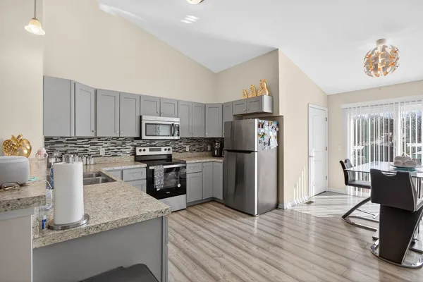 a kitchen with granite countertop a refrigerator stove and sink