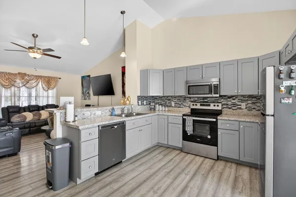 a kitchen with kitchen island granite countertop a sink appliances cabinets and furniture