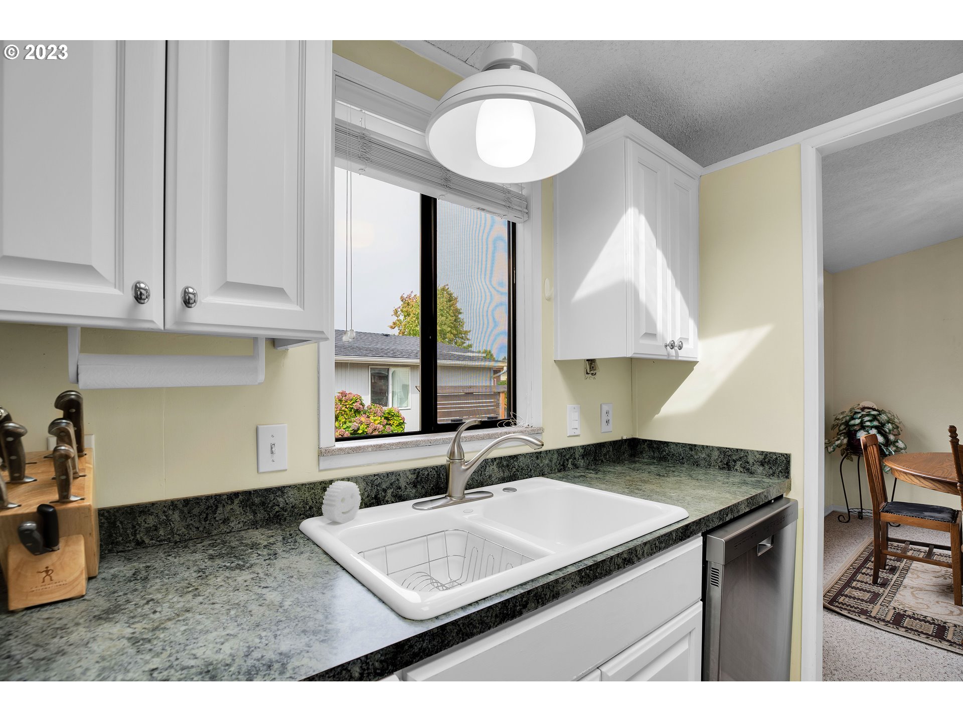 4304 Settlers Loop Forest Grove, OR 97116 - Photo 14 of 45 a kitchen with granite countertop a sink a stove and a wooden cabinets