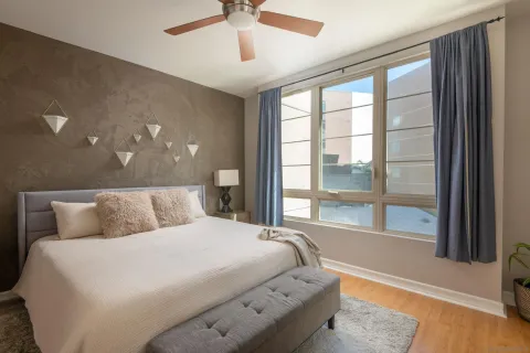 a bedroom with a large bed and a large window with the outer view