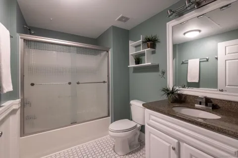 a bathroom with a granite countertop sink toilet and shower