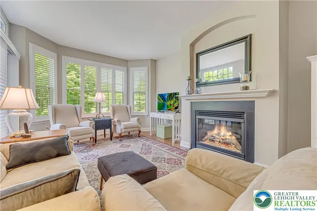 a living room with furniture a large window and a fireplace