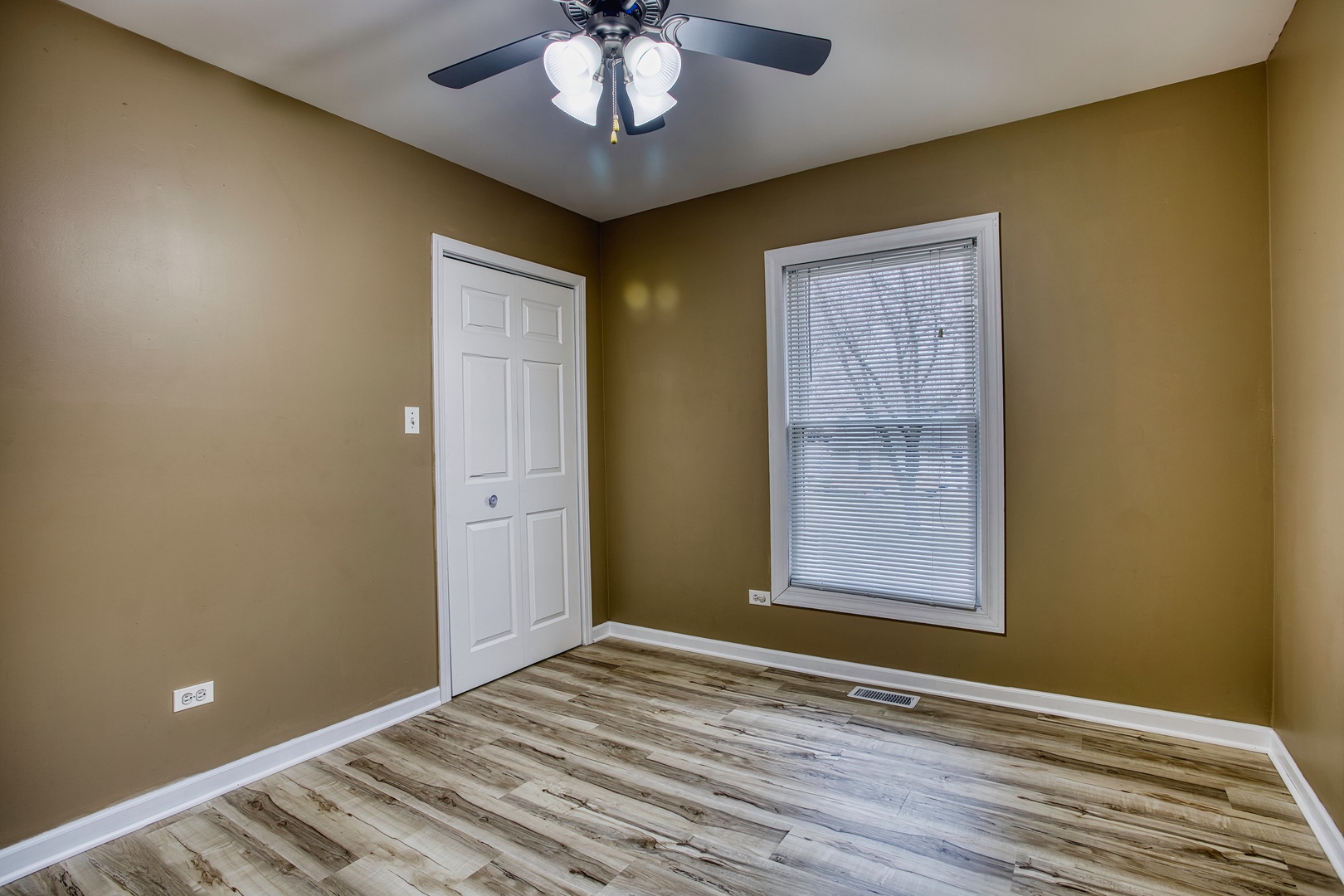 805 Stowell Avenue Streamwood, IL 60107 - Photo 14 of 30 a view of an empty room with a window and wooden floor