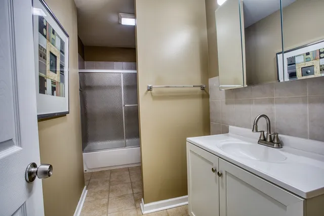 a bathroom with a sink a mirror and shower