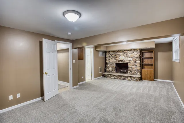 an empty room with fireplace and fan