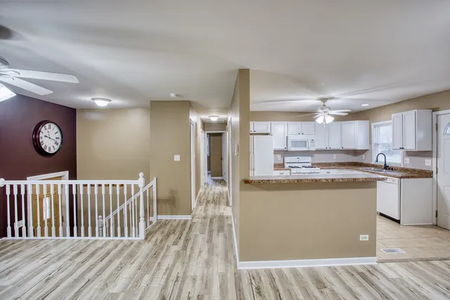 a kitchen with kitchen island granite countertop a refrigerator and a sink