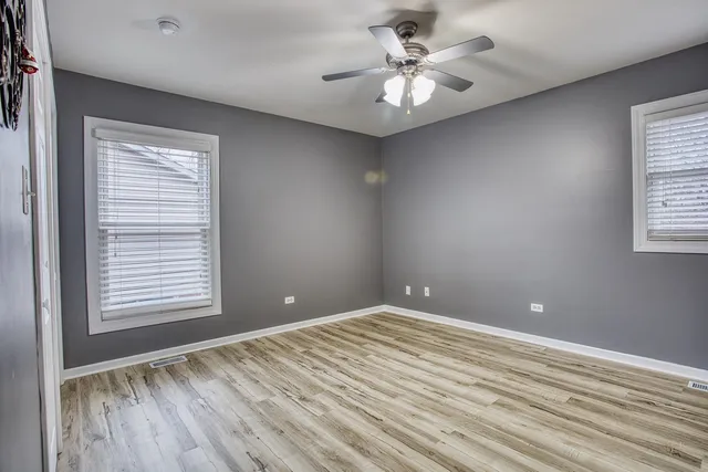 a view of empty room with window and ceiling fan