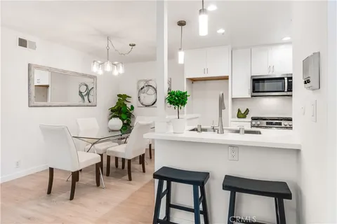 a kitchen with a table chairs sink and cabinets