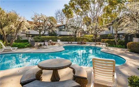 a view of a patio with table and chairs potted plants and a large tree