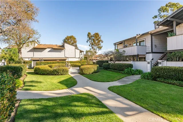 a front view of a house with a garden and a tree
