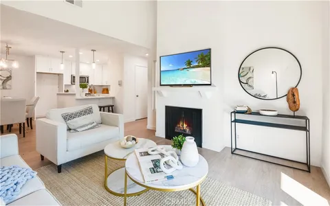 a living room with furniture a fireplace and kitchen view