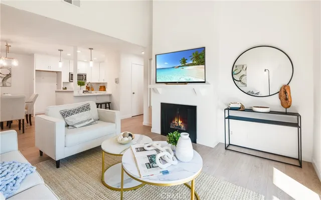a living room with furniture a fireplace and kitchen view