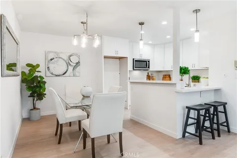 a kitchen with white cabinets and chairs