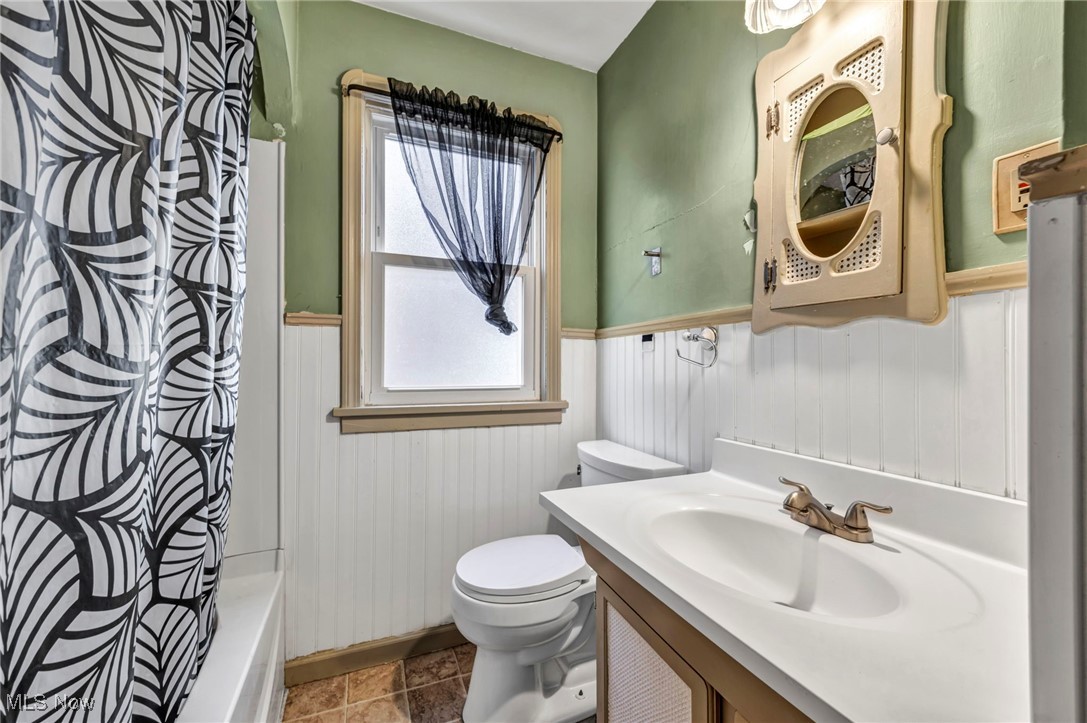 8017 Ackley Road Parma, OH 44129 - Photo 24 of 43 Full bath featuring a wainscoted wall, vanity, and shower / bath combo