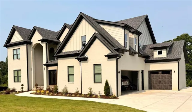 a front view of a house with a garden and yard