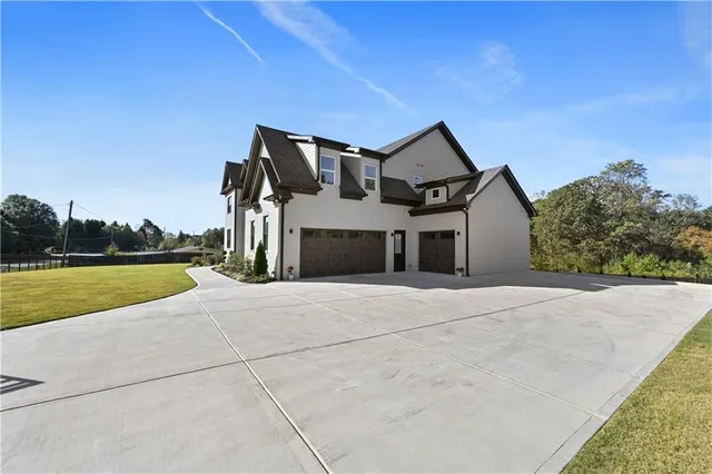 a front view of a house with swimming pool and yard
