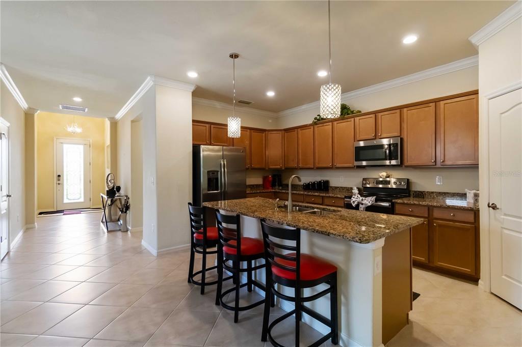 1480 Mossy Oak Drive North Port, FL 34287 - Photo 13 of 39 a kitchen with stainless steel appliances granite countertop a stove top oven a sink refrigerator and cabinets