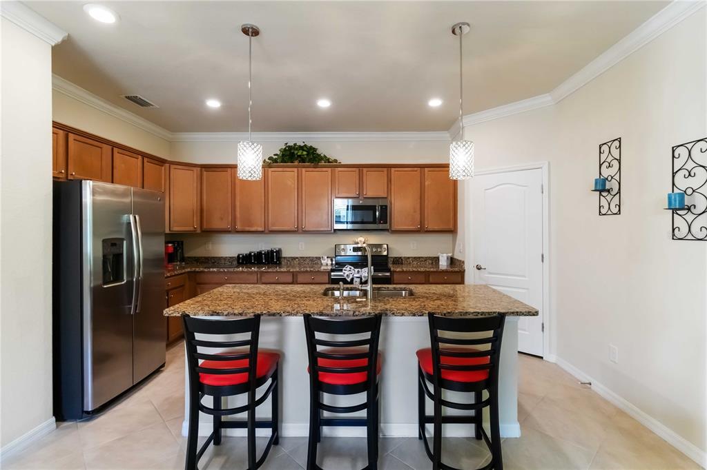 1480 Mossy Oak Drive North Port, FL 34287 - Photo 19 of 39 a kitchen with a refrigerator and a dining table