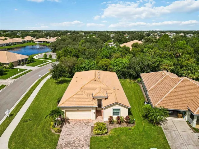 an aerial view of a house with a garden and lake view