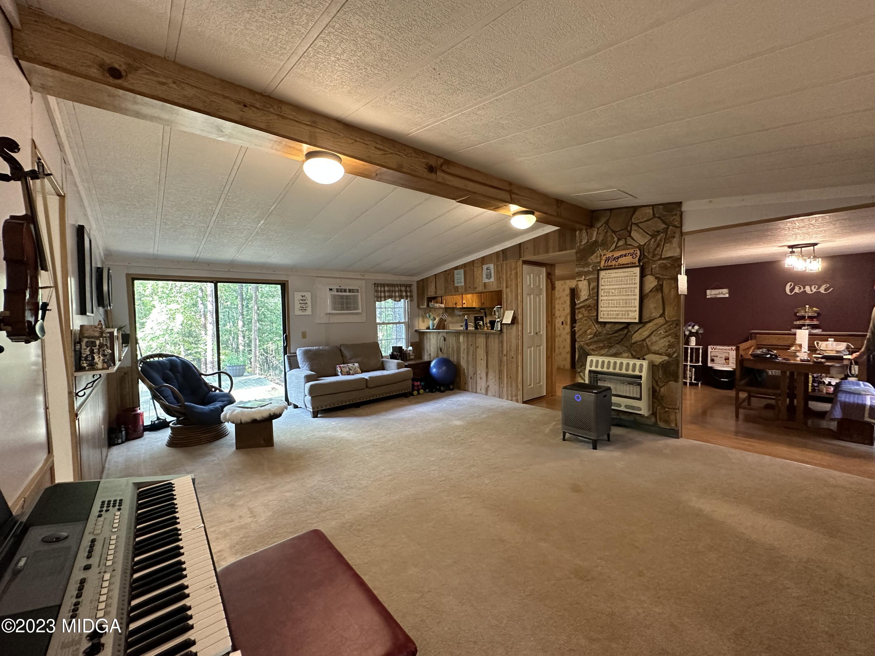 533 Giles Road Forsyth, GA 31029 - Photo 5 of 28 a living room with furniture a flat screen tv and a large window