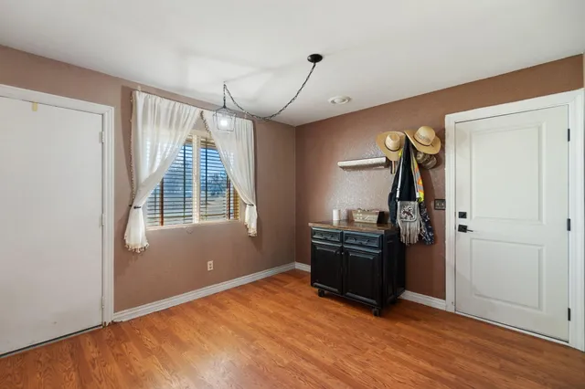a view of a livingroom with wooden floor furniture and windows