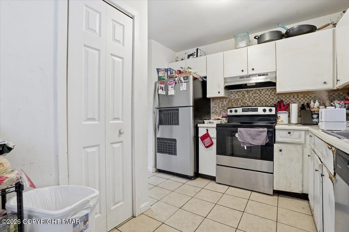 3322 Windermere Drive Bushkill, PA 18324 - Photo 11 of 52 a kitchen with stainless steel appliances a white refrigerator a stove a microwave and cabinets