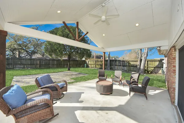 a view of a patio with couches chairs and a yard