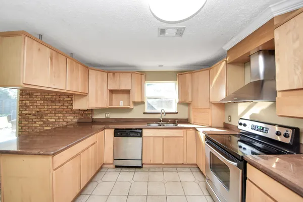 a kitchen with a stove sink cabinets and a window