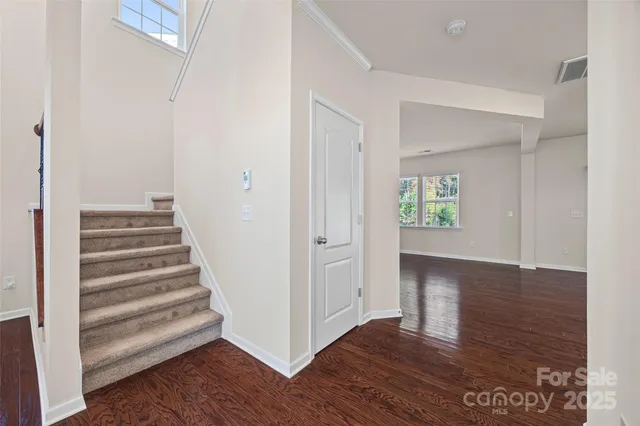 a view of a hallway with wooden floor and a ceiling fan
