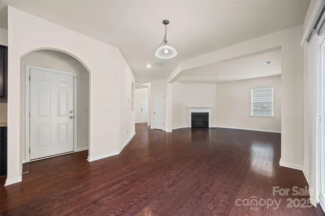a view of a livingroom with wooden floor and a ceiling fan