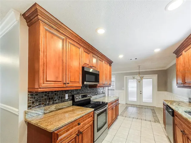 a kitchen with granite countertop a stove a sink and a microwave