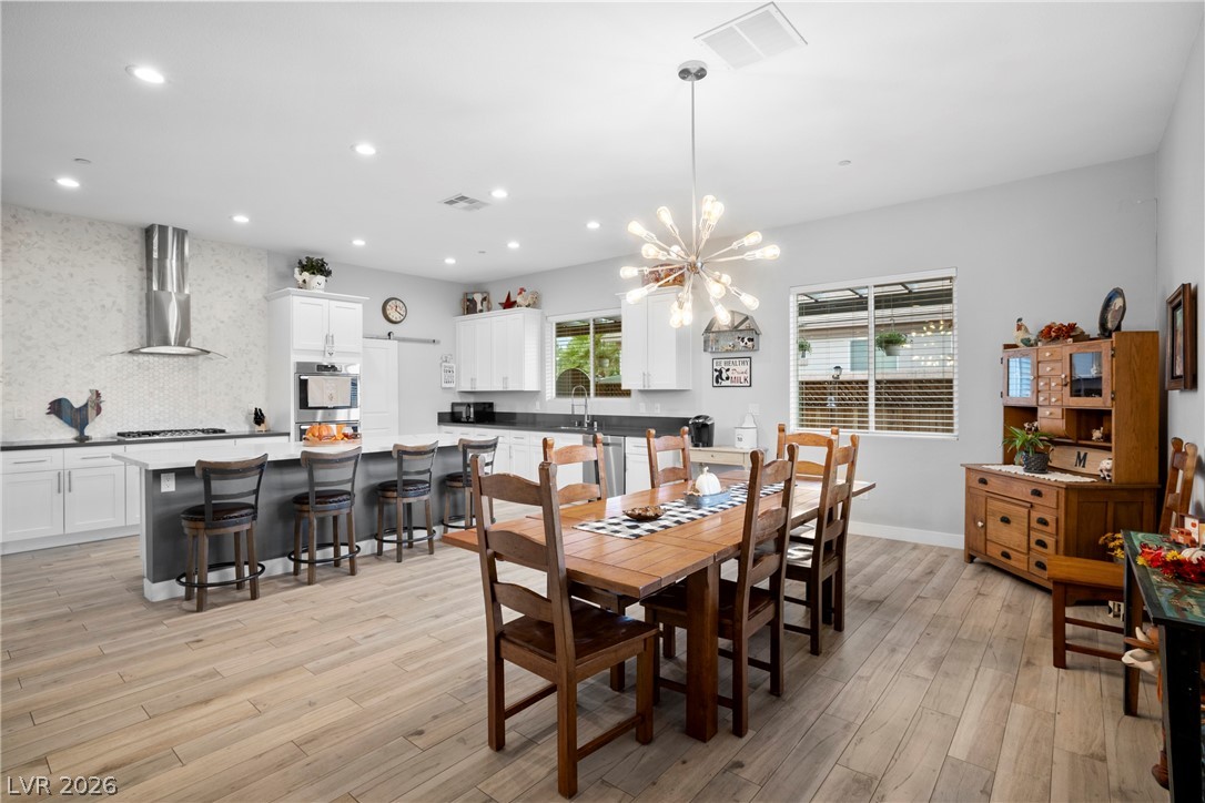432 North Racetrack Road Henderson, NV 89015 - Photo 7 of 45 Dining room featuring light wood-type flooring, a chandelier, and healthy amount of natural light