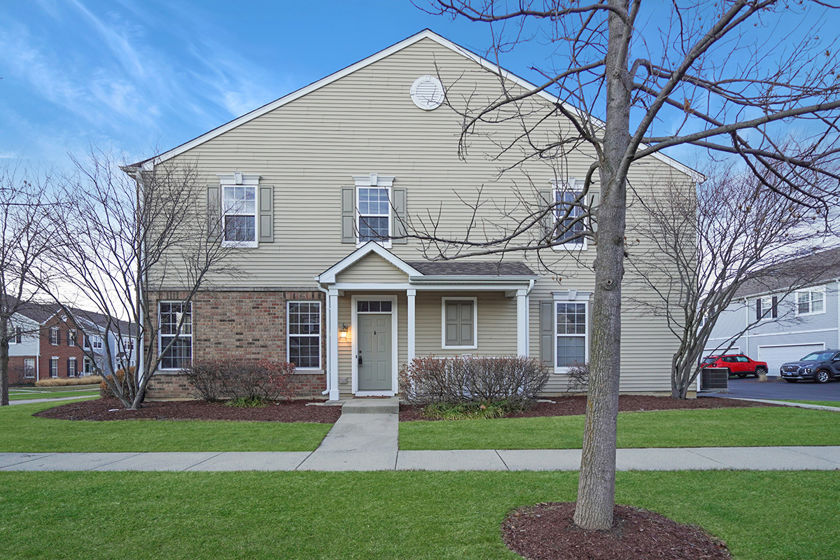 321 Springbrook Trail South Oswego, IL 60543 - Photo 2 of 2 a front view of a house with a garden and trees