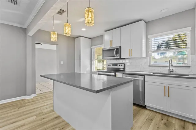 a kitchen with stainless steel appliances granite countertop a sink a stove and cabinets