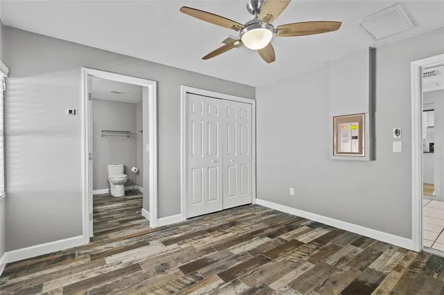 a view of a room with wooden floor and a ceiling fan
