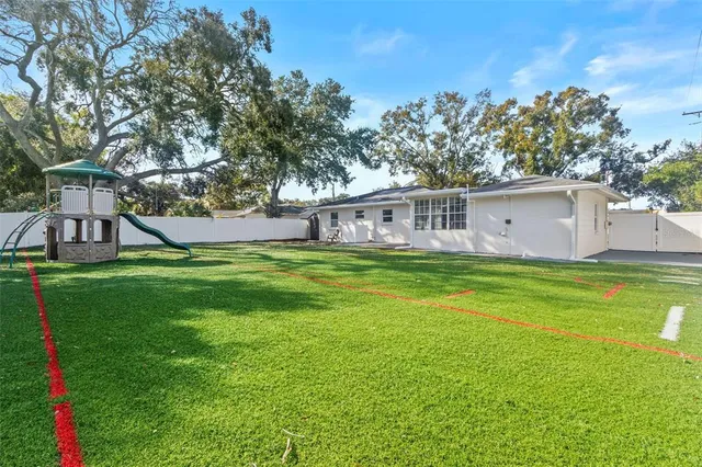 a view of a house with a big yard and large trees