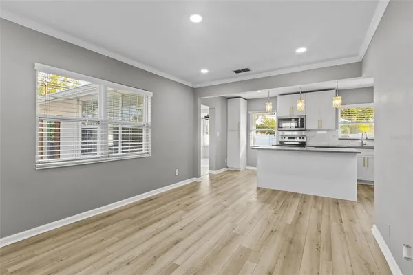 a large kitchen with kitchen island white cabinets and stainless steel appliances