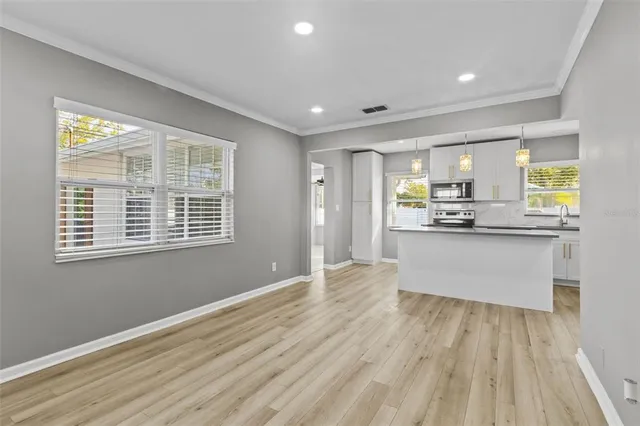 a large kitchen with kitchen island white cabinets and stainless steel appliances