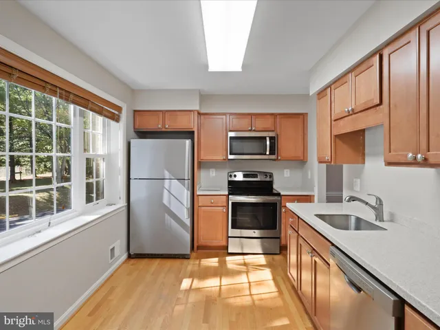 a kitchen with stainless steel appliances granite countertop a sink a stove a refrigerator a stove a microwave and cabinets