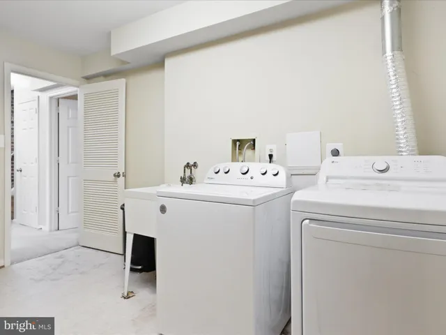 a view of a hallway with wooden floor and a bathroom