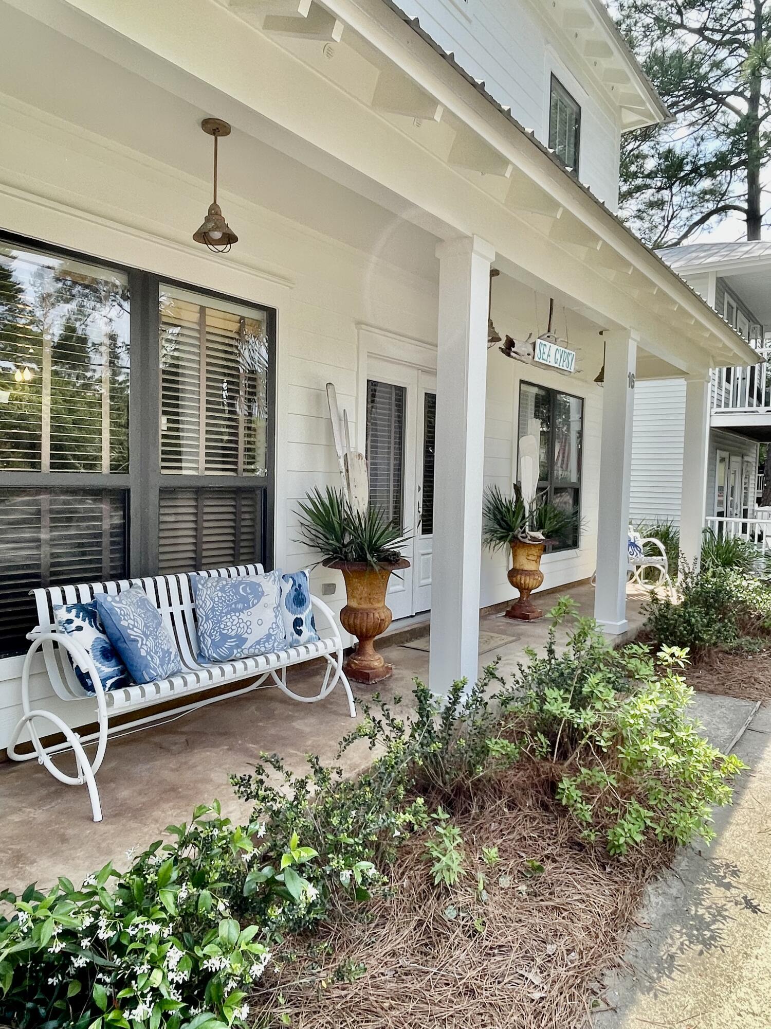 a view of a patio with table and chairs potted plants and floor to ceiling window