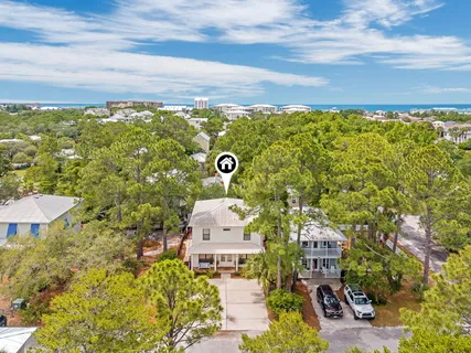 an aerial view of residential houses with outdoor space and trees all around