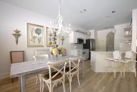 a view of a dining room with furniture a chandelier and wooden floor